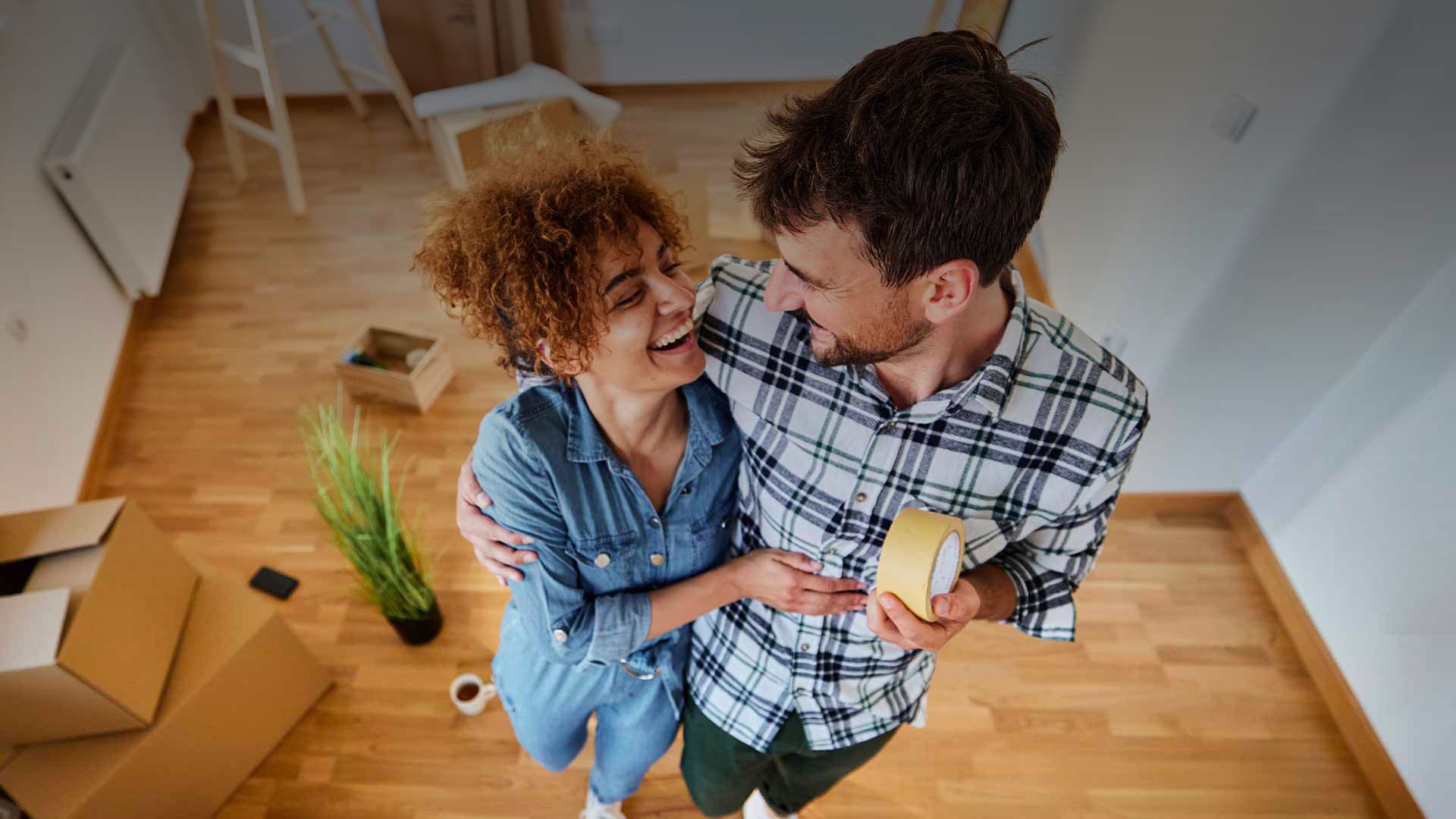 Mutui BNL: fotografia di un uomo e una donna che ridono abbracciati tra gli scatoloni del trasloco