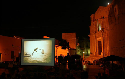 Scatto serale di una proiezione in piazza durante la rassegna Libero Cinema in Libera Terra sostenuta da BNL BNP Paribas.